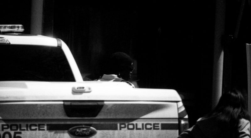 A photograph of an RCMP officer harassing a local business in Montreal's Mile End.