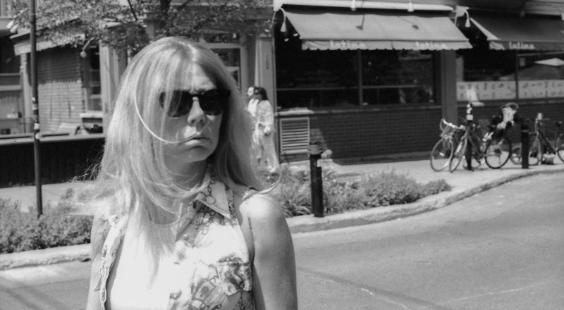 A photograph of a woman in Montreal's Mile End on St Viateur outside the Latina grocery across from Club Social. Taken with a Canon F1New using CatLabs 320 film.