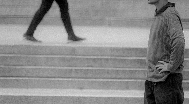 A photograph of a man with a skateboard and a woman walking in the other direction at the lookout atop Mont Royal in Montreal. Taken with a Canon F1New camera and a Canon FD 100-300mm lens with CatLabs 320 film.
