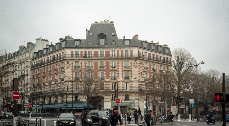 A photograph of an intersection and apartment building in the background on Boulevard Belleville in Paris. Taken with a Nikon L35AF using Fujicolor Colorplus 400 film.