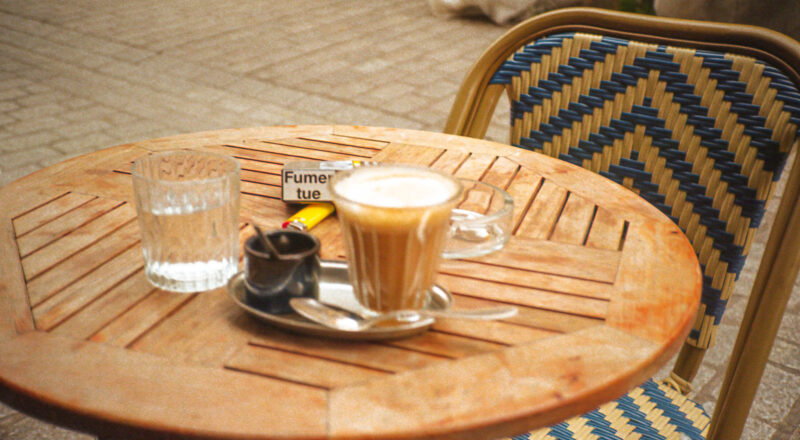 A photograph of a coffee and cigarettes outside of a hotel in Paris. Taken with a NIkon L35AF and Fujicolor Colorplus 400 film.