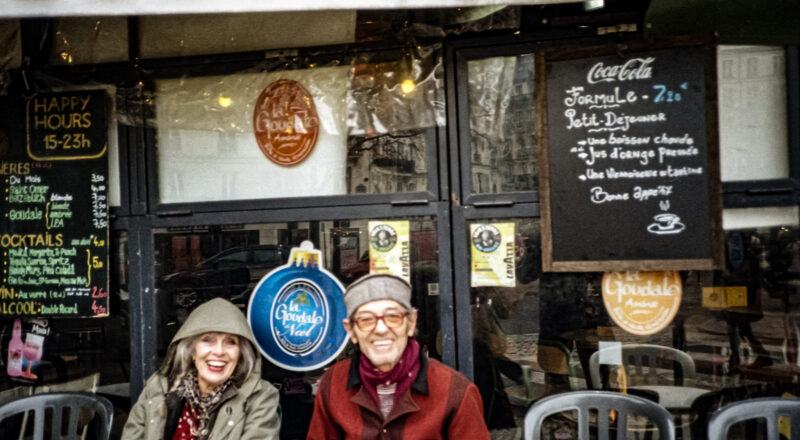 A photograph of a lovely couple enjoying a beverage outside of a small bar on Boulevard Belleville in Paris. Taken with a Nikon L35AF using Fujicolor Colorpluss 400 film.