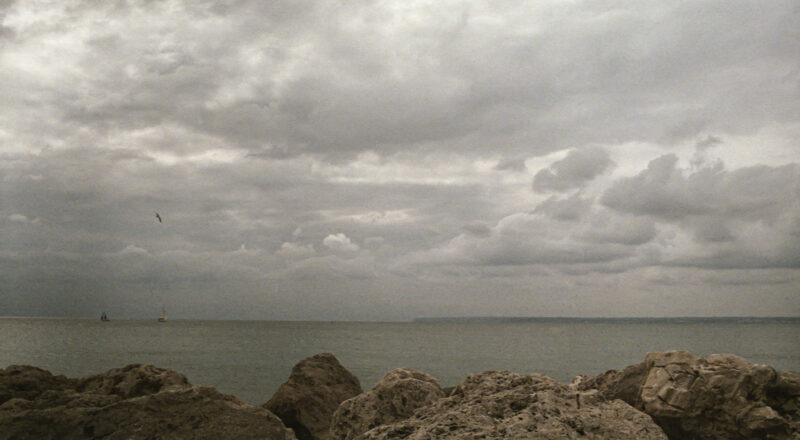 A photograph of a dramatic sky in Palma de Mallorca with fishing boats on the horizon.