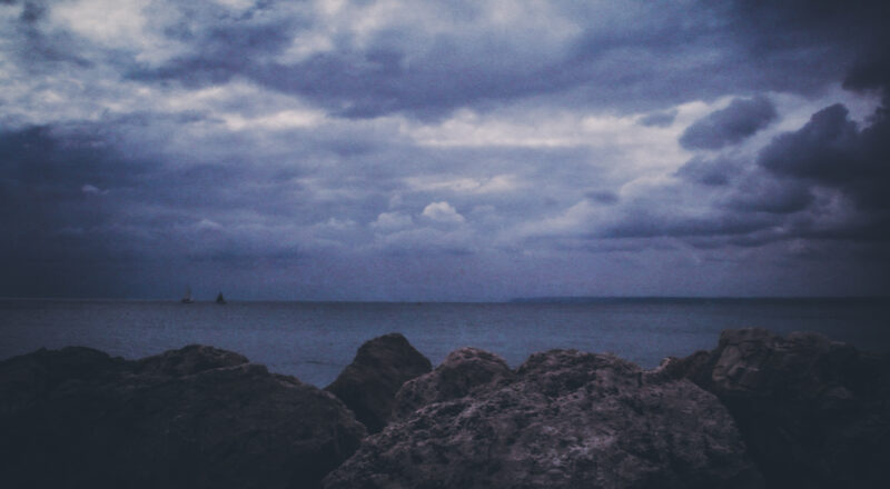 A photograph of a dramatic sky in Palma de Mallorca with fishing boats on the horizon.