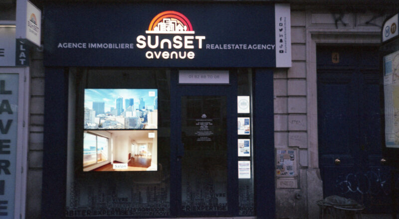 A photograph of Sunset Avenue Agence immobiliere in Paris. Taken with a Nikon L35AF using Fujicolor Colorplus 400 film.