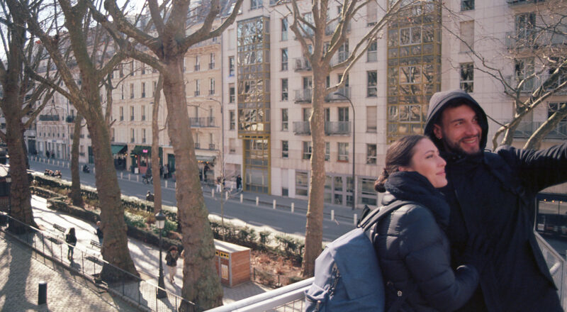 A couple takes a selfie on a bridge in Paris.