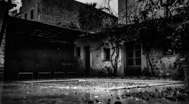 A photograph of a backyard pool on a rainy day in Soller de Mallorca.