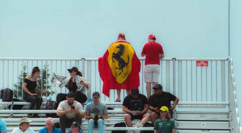 A photograph of a Ferrari fan during the qualifying round of the 2023 Canadian Grand Prix in Montreal at the Circuit Jacques Villeneuve. Taken with a Canon F1New film camera using Kodak Ektar 100 Professional film.