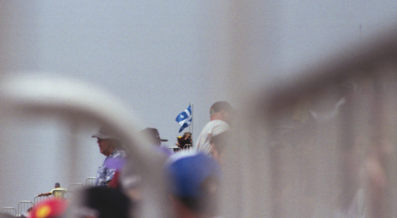 A photograph of a Quebec flab being flown during the qualifying round of the 2023 Canadian Grand Prix in Montreal at the Circuit Jacques Villeneuve. Taken with a Canon F1New film camera using Kodak Ektar 100 Professional film.
