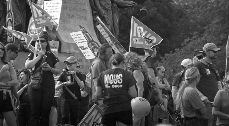 A photograph from a union rally in support of Quebec service workers including teachers and nurses near the Sir George-Etienne Cartier Monument in Montreal during the summer of 2023. Taken with a Canon F1New using CatLabs 320 film.