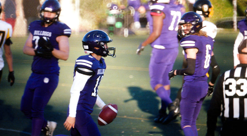 A photograph of a quarterback holding a ball, taken at the Parc Jeanne Mance multipurpose field.